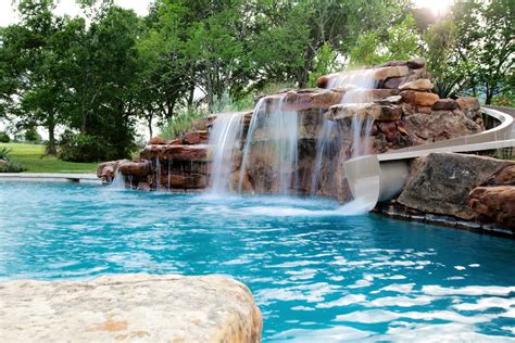 A Beautiful Free Form Pool Design With A Rock Wall Water Feature And