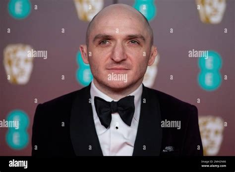 Alexandre Desplat poses for photographers upon arrival at the Bafta