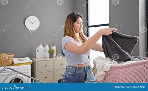 Young Blonde Woman Hanging Clothes On Clothesline At Laundry Room Stock