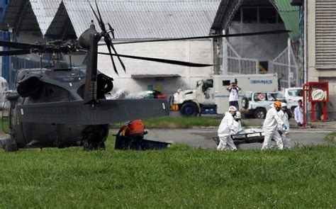Servicios de rescaten transporten un cuerpo del accidente de avión. Recuperados los cuerpos de los 71 muertos en el accidente ...
