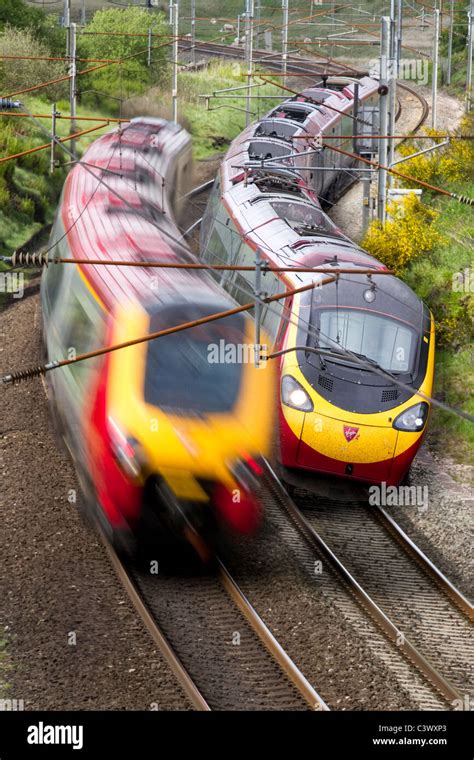 Two Virgin Rail Passengers Tilting Trains Passing Each Other Travelling