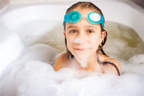 Funny Little Positive Caucasian Girl Wearing Swimming Goggles And Plays
