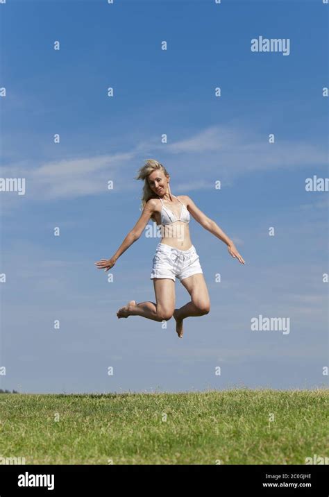 Happy Woman In White Bikini And Shorts Jumps In A Stock Photo Alamy
