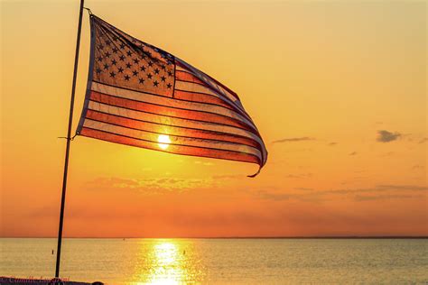 The American Flag Flying High At Sunset Photograph By Camille Lucarini