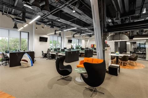 An Office With Chairs Desks And Television Screens