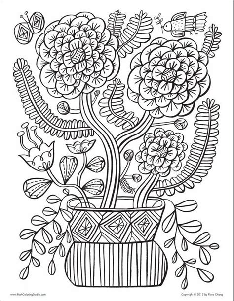 a vase filled with flowers on top of a white table next to leaves and