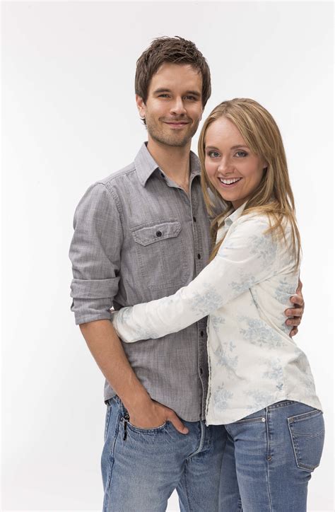a man and woman standing next to each other in front of a white background with their arms