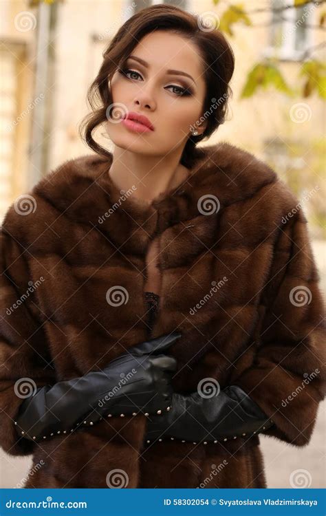 Glamour Woman Wearing Fur Coat Red Lingerie And Stockings Posing In Front Of Interior