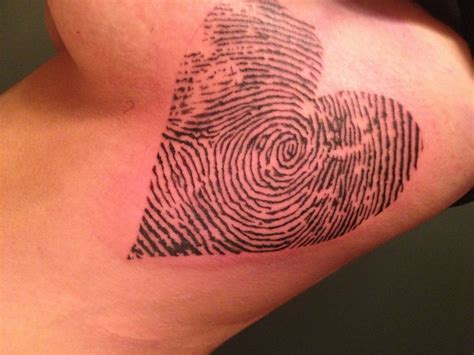 A Heart Shaped Fingerprint Tattoo On The Back Of A Womans Shoulder And Arm