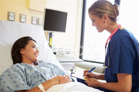 Nurse Talking To Female Patient On Ward Stock Photos