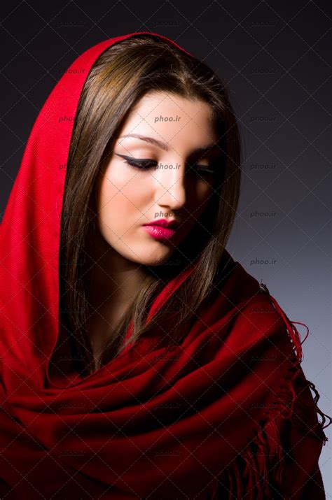 عکس دختر زیبا با آرایش صورت و شال قرمز در پس زمینه مشکی عکس با کیفیت و تصاویر استوک حرفه ای