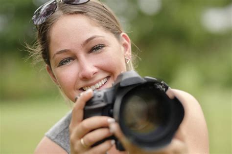 Close Up Portrait Of Smiling Woman Using Dslr Camera Outdoors