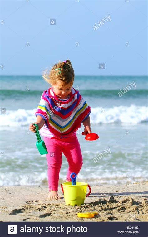 A Two Year Old Girl Plays On Meelup Beach With Her Plastic Toys During Winter In Western