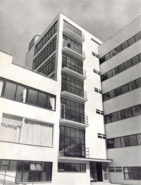 An Old Black And White Photo Of A Tall Building With Balconies On The