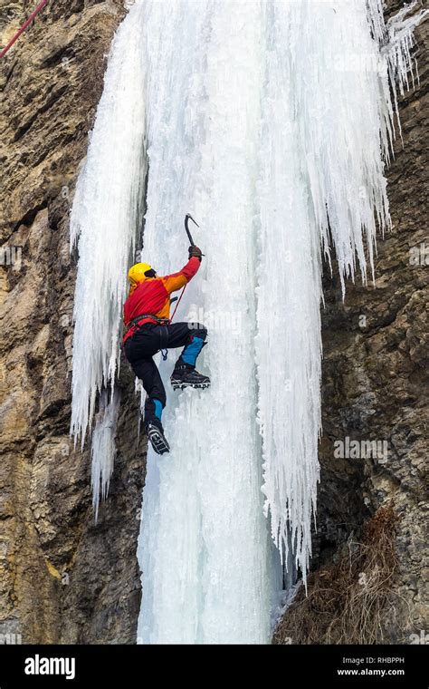 Extreme Ice Climbing Man Climbing The Frozen Waterfall Using Ice Axes