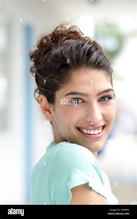 Female With Wavy Brunette Hair Tied Up Wearing A Pale Mint Green Top