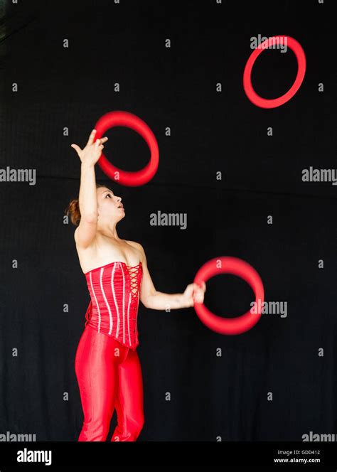 Young Female Juggler In A Red Basque Throwing And Catching Red Juggling