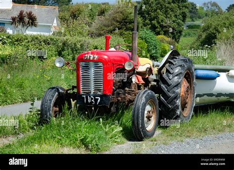 Old Red Tractor On The Side Of A Road In Guernsey Channel Islands Stock