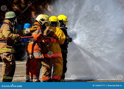 Two Brave Firefighter Using Extinguisher And Water From Hose For Fire