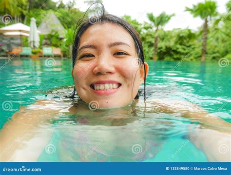 Young Happy And Sweet Asian Chinese Woman Swimming In Tropical Resort