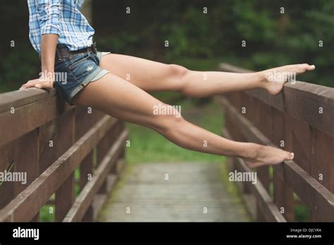 Stretched Legs Of Woman Sitting On Bridge Stock Photo Alamy