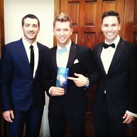 Three Men In Tuxedos Are Posing For The Camera
