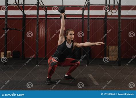 Crossfit Woman Doing Overhead Dumbbell Squats At The Gym Stock Image