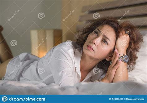 Dramatic Lifestyle Portrait Of Attractive Sad And Depressed Middle Aged Around 50s Woman Feeling