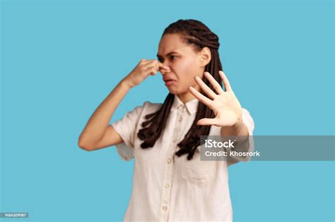 woman pinching nose stop breathing disgusted by smell of farting showing stop gesture stock