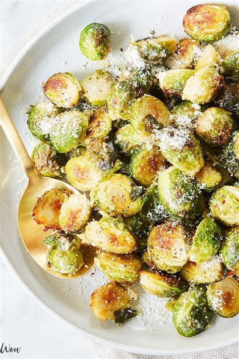 Brussel Sprouts With Parmesan Cheese On A White Platter
