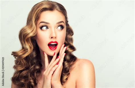 shocked and surprised girl looking to the side presenting your product curly hair woman amazed