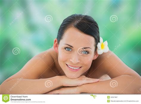 Beautiful Brunette Relaxing On Massage Table Smiling At Camera Stock