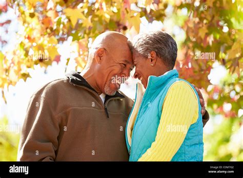 Senior Couple Walking Through Autumn Woodland Stock Photo Alamy