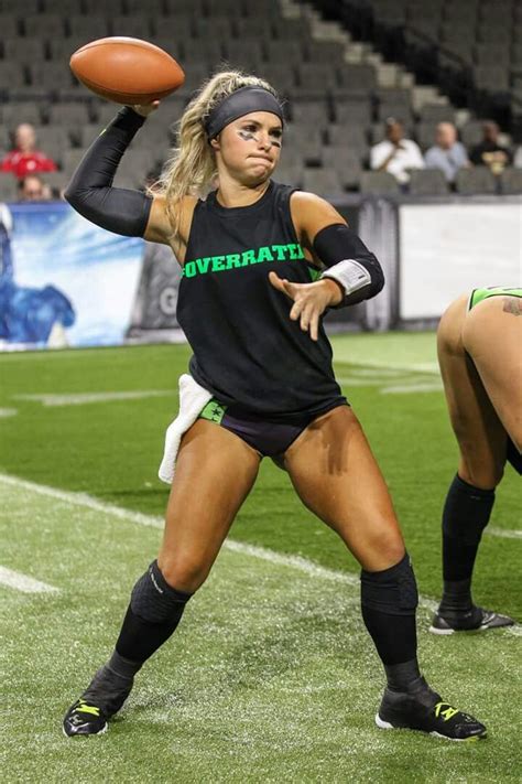 A Woman Holding A Football On Top Of A Field