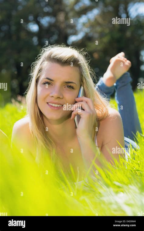 Pretty Blonde Lying On Grass Talking On Phone Smiling At Camera Stock