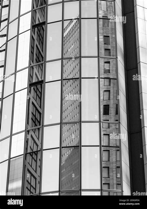 Vertical Greyscale Facade Of A Modern Office Building With Glass