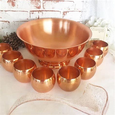An Assortment Of Copper Colored Bowls And Cups