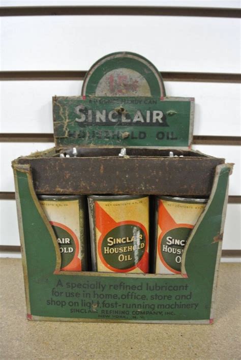 An Old Fashioned Gas Station Sign With Three Cans In Its Display Case
