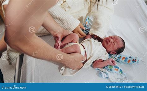 Multiethnic Couple Holding And Admiring Their Newborn Baby In Hospital