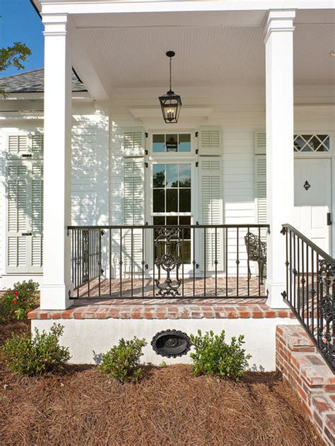 Bright wrought iron railings look houston traditional exterior decorating ideas with curb appeal dormers flags front door front steps grass hanging plants hip roof iron fence iron gate iron railing lawn scallops shrubs shutters wraparound porch yellow siding thank to creole design. Iron Front Porch Railing Ideas, Pictures, Remodel and Decor