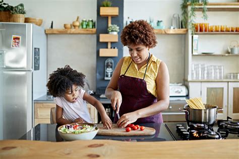Afrocaribbean Mother And Young Daughter Cooking Together Fotografias