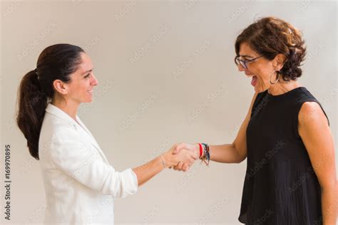 Dos Mujeres Dándose La Mano Sonrientes Stock Photo Adobe Stock