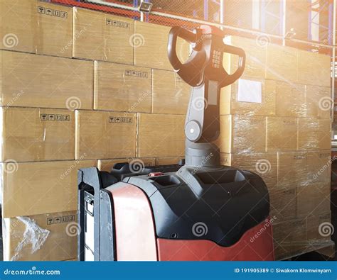Stack Of Shipment Cardboard Boxes With Electric Forklift Pallet Jack At Warehouse Storage Cargo