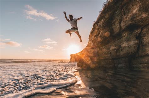 Man Jumps From Cliff To Water · Free Stock Photo