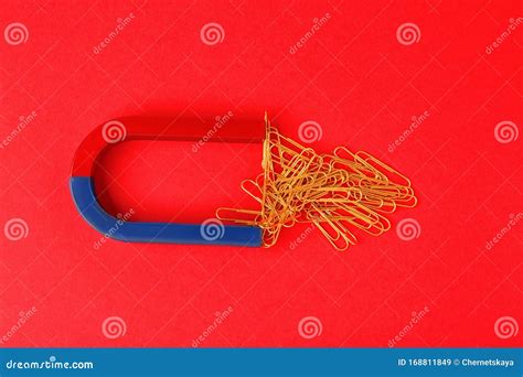Magnet Attracting Paper Clips On Red Background Stock Image Image Of