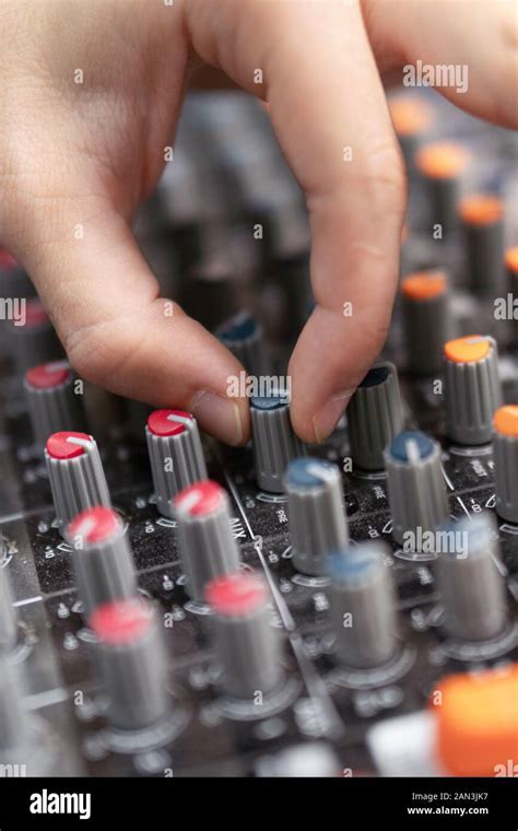 Close Up Of A Mixing Console Hand Equalizing Audio Channels