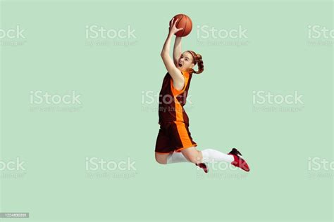 Young Caucasian Female Basketball Player Against Mint Colored Studio