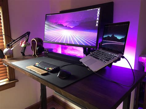 A Desk With Two Computers And Headphones On It