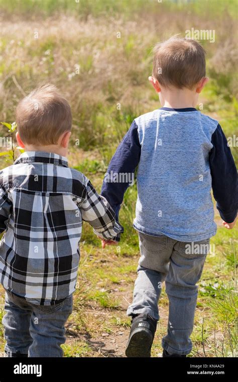 Lifestyle Portrait Of Two Young Brothers Playing Together And Exploring