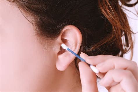 Close Up Of Woman Cleaning Her Ear With A Cotton Swab Stock Photo